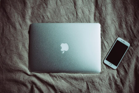 MacBook and iPhone on bed photo