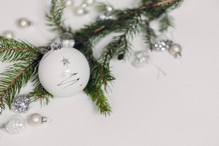 White and silver baubles with a spruce twig photo