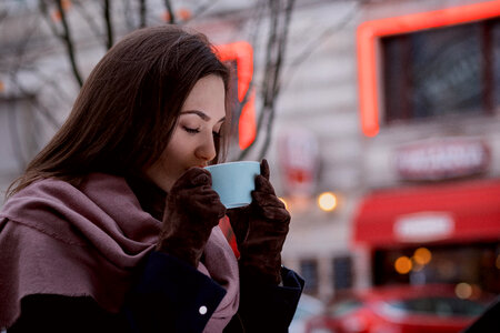 A woman drinking coffee outdoors photo