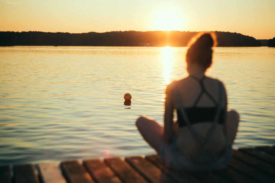 A girl sitting on a pier blurred
