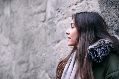 A girl leaning against a wall photo