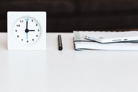 A table clock, a planner and a phone photo