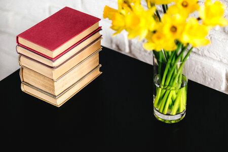 Spring daffodils and books on black table photo