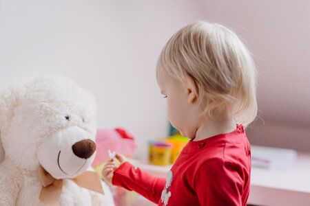 A little girl feeding her teddy photo
