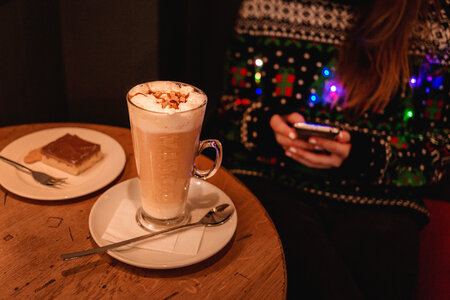 Girl in Christmas sweater sitting in a cafe photo