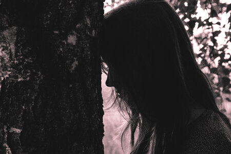 Girl leaning against the tree photo