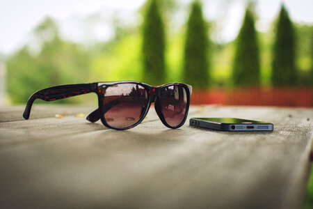 Sunglasses and phone on the table photo