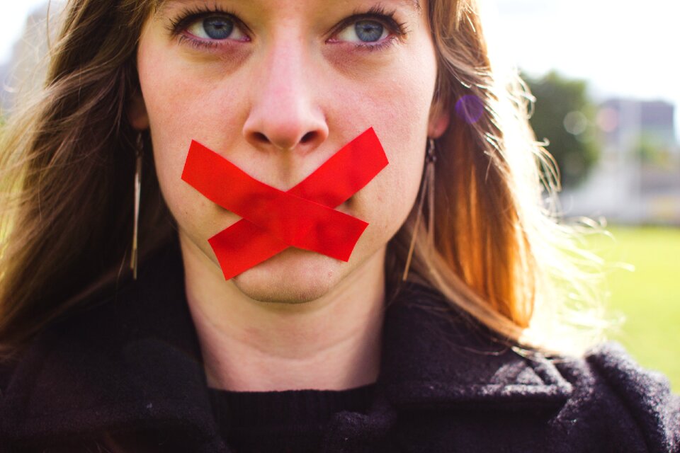 Woman With Red Cross Tapes on Mouth Wearing Black Top