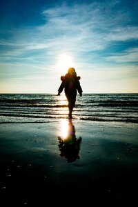 Silhouette Photography of Person Walking on Shoreline photo