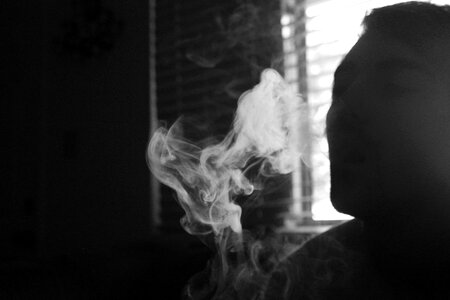 Gray Scale Photo of Human Smoking Inside the Room photo