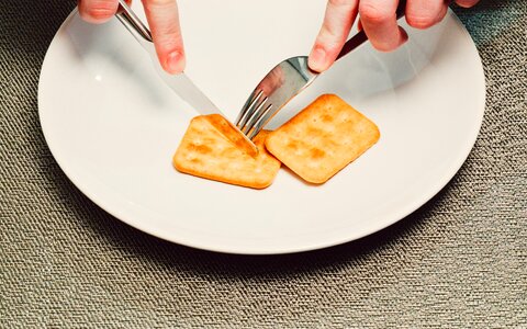 Person Slicing Biscuit Using Stainless Steel Butter Knife