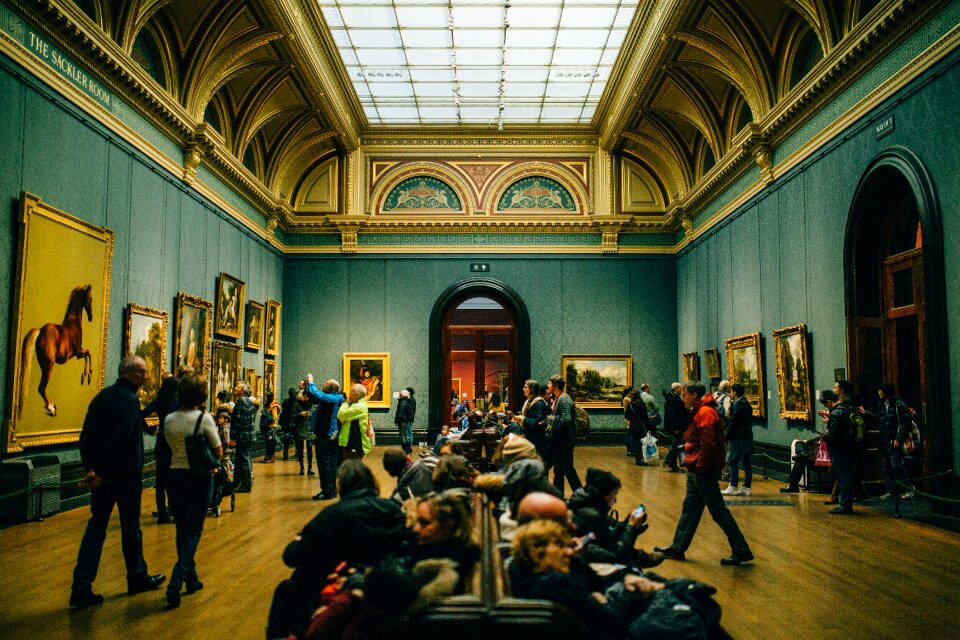 People Walking on Wooden Floor Inside Green Walled Building photo