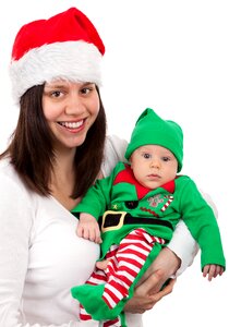 Smiling Woman Wearing Santa Hat Carring Baby Wearing Elf Costume