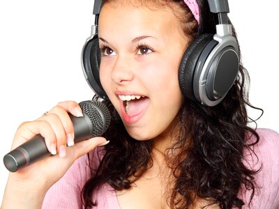 A Girl Holding a Microphone With a Headphone photo