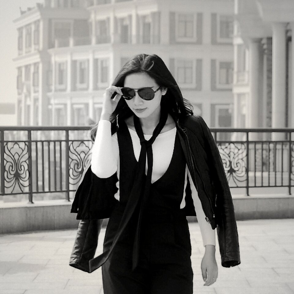 Greyscale Photo of Woman Wearing Sunglasses Long Sleeves Shirt and Skirt during Daytime photo