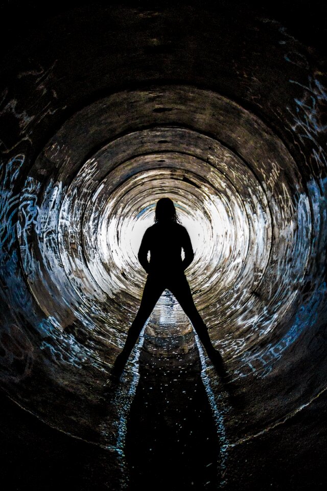 Silhouette of Person Inside Concrete Drainage