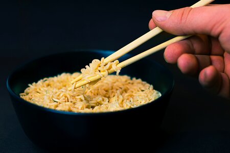 Person Holding a Chopsticks and Picking a Noodles in Black Bowl photo