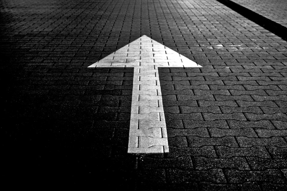 White Arrow Direction on Black Pavemet