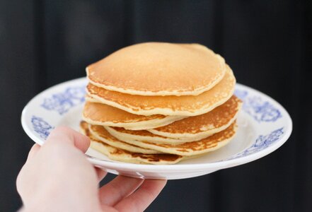 Person Holding Plate With Pancakes photo