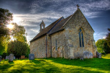 Gray and Yellow Stone Church on Green Grass Lawn Surrounded by Cemetery Under Gray Sky during Day Light photo