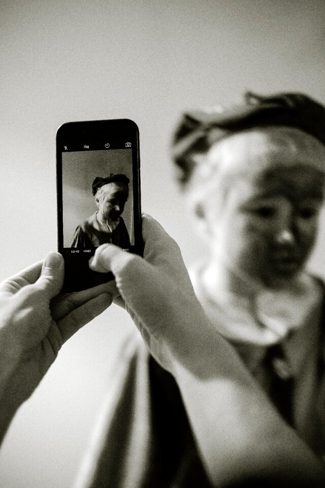 Person Taking Photo of Statue Grayscale Photo