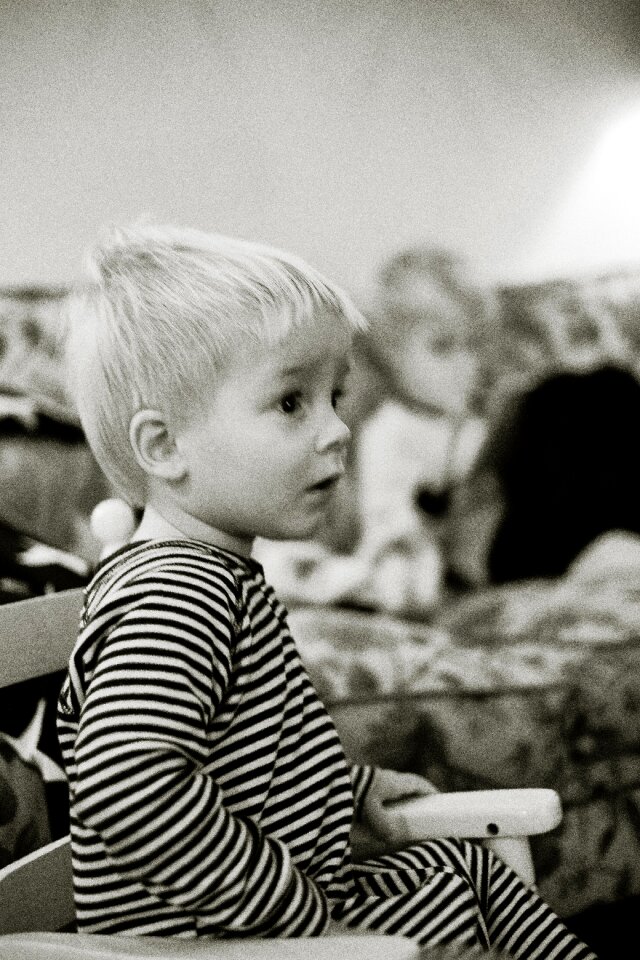 Grayscale Photo of Boy Sitting on Armchair photo