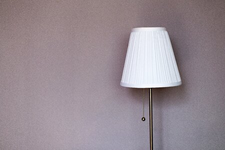 White and Grey Metal Pedestal Lamp Nearby Grey Painted Wall