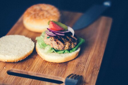 Shallow Focus Photography of Burger Sandwich Served on Brown Wooden Chopping Board photo
