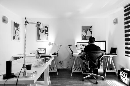Grayscale Photography of a Man Sitting Infront of a Computer photo
