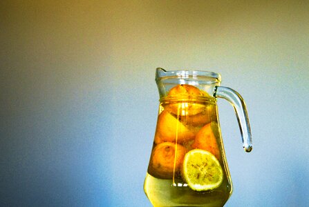 Clear Glass Pitcher With Sliced Yellow Round Fruit Inside