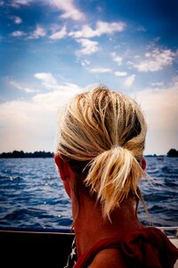 Person's Blonde Hair Looking at Body of Water photo