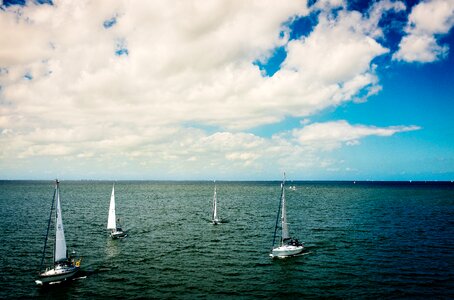 White Sail Boat on Body of Water Under Blue Cloudy Sky during Daytime