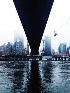 Body of Water Under Bridge Near Buildings Under White Clouds during Cloudy Day photo