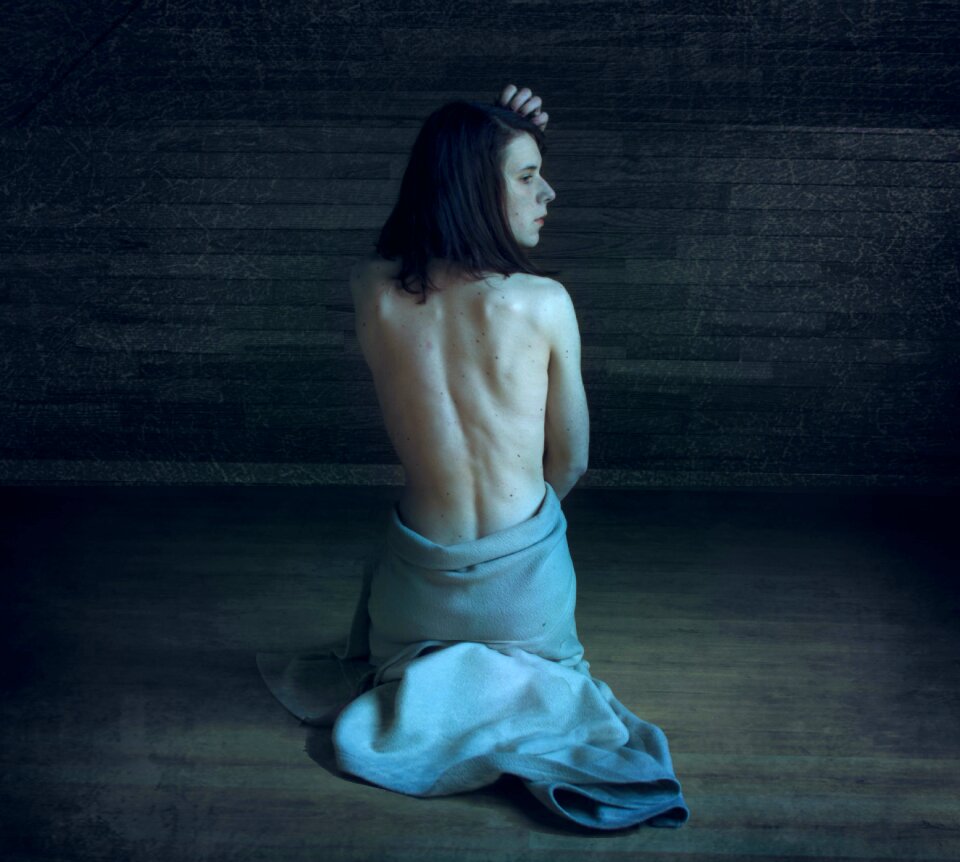 Woman Wearing Gray Skirt Sitting on Brown Wooden Floor