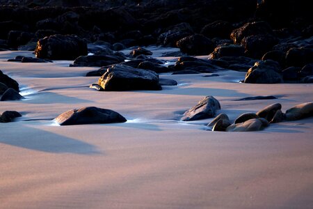 Black Rocks on Sand during Daytime photo