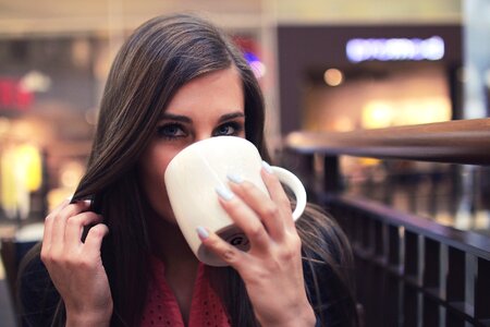 Woman in Black Mascara Drinking on White Ceramic Mug photo