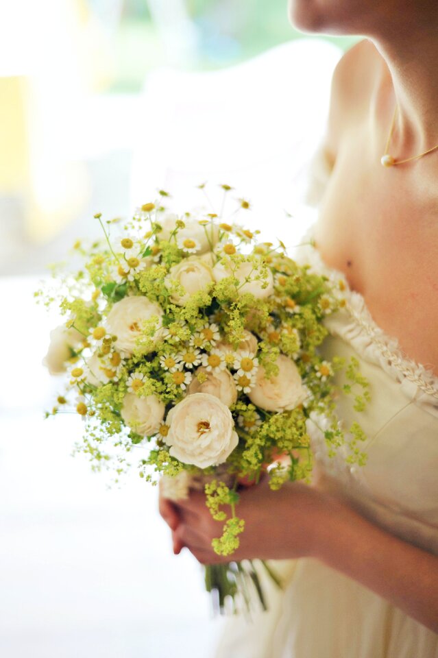 Woman in Bridal Gown Holding Bouquet of White Flowers photo