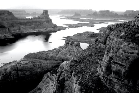 Grayscale Photography of High Rise Rock Near Body of Water photo