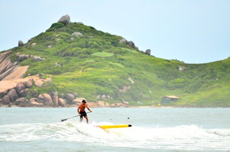 Man in Black Shorts Surfing Under Blue Sky during Daytime photo