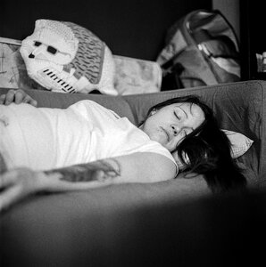 Woman in White Shirt Sleeping on Gray Fabric Sofa photo