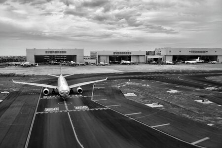 Gray Scale of Air Plane on Runway Under Cloudy Day photo