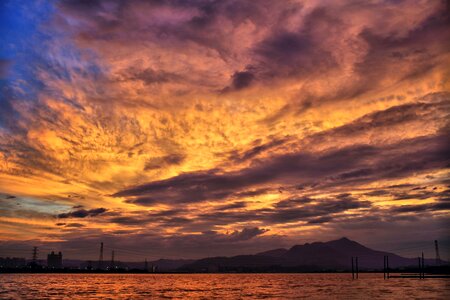 Sea and Silhouette of Mountain Under Orange Sky during Golden Hour photo