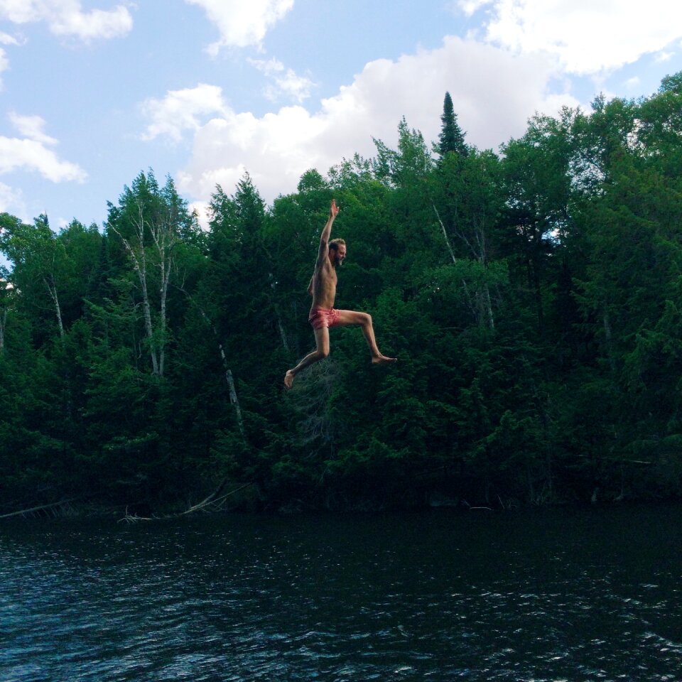 Man in Pink Shorts Jumping on Body of Water