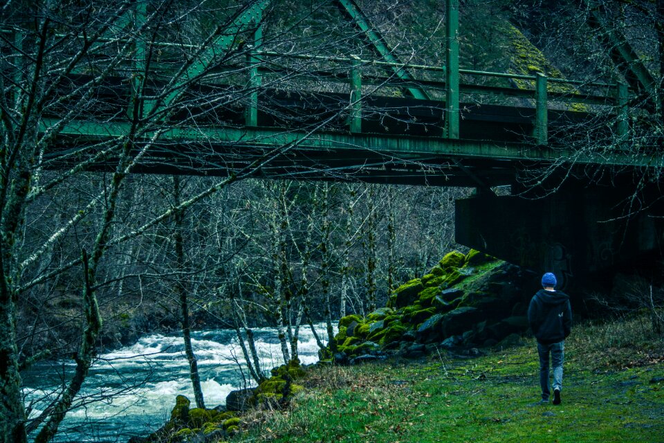 Man Walking Under Bridge Beside River