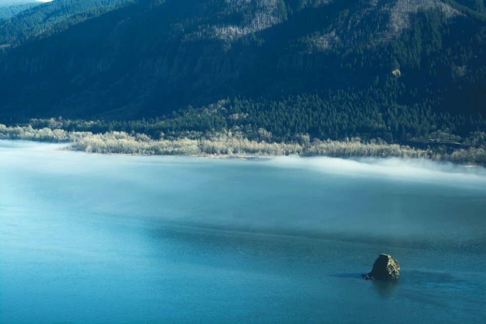 Green Stone in Body of Water Near Mountain photo