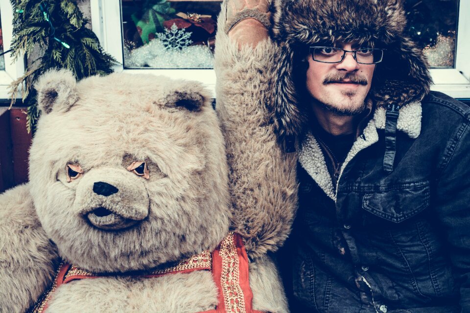 Man in Black Jacket Beside Bear Mascot