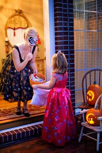 Woman Making Trick of Treat in Front of a Girl photo
