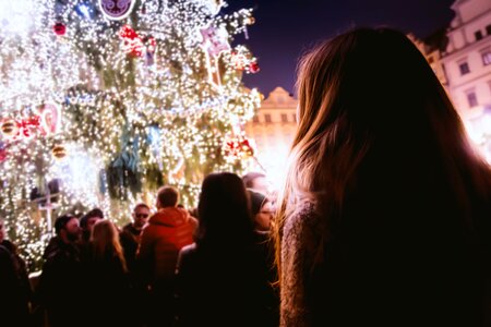 People Standing Facing Christmas Tree With Lights during Night Time photo