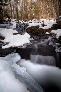 Water Flowing Through Snow Covered Forest photo