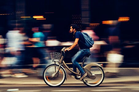 Man Riding Bicycle on City Street photo